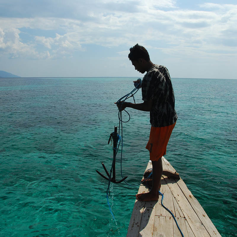 Young Indonesian fisherman anchoring