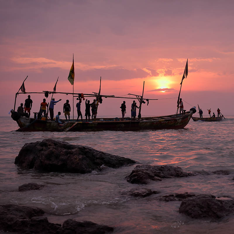 Traditional fishermen setting out to sea at sunrise in Africa