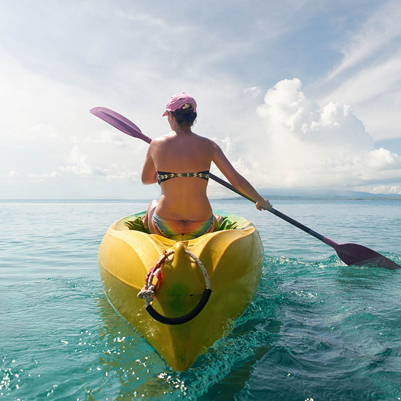 Woman kayaking in a tropical setting