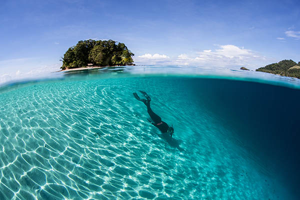 A snorkeler does some free diving along a sandy slope in the Solomon Islands