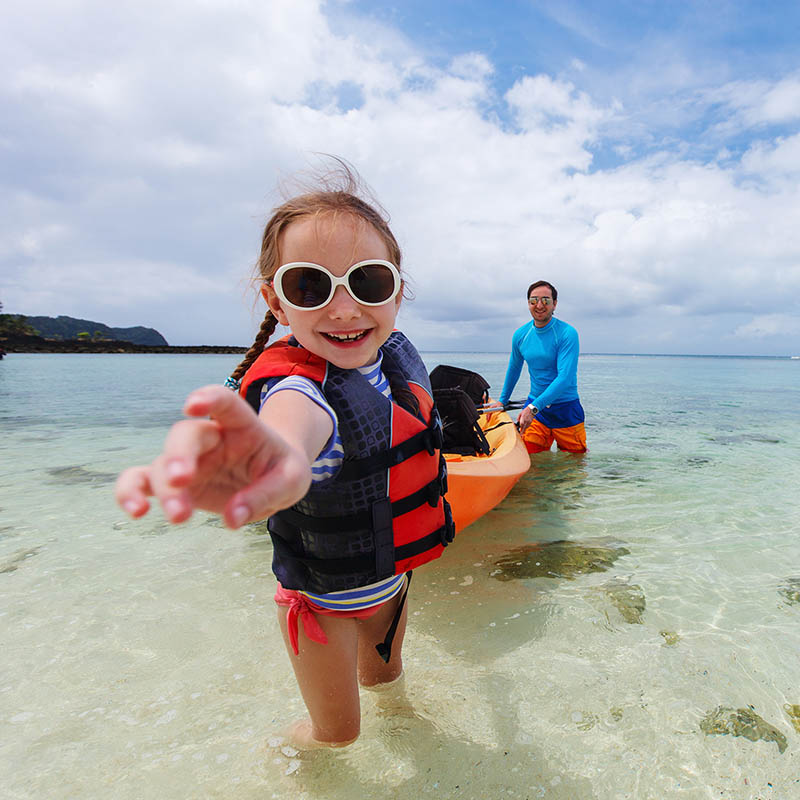 Father and daughter kayaking at tropical ocean on summer vacation