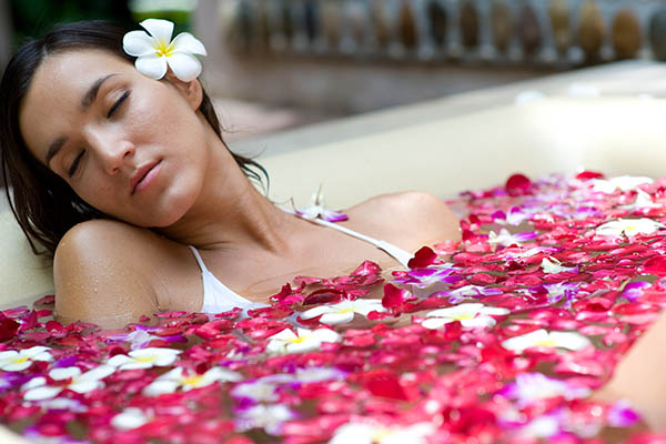 Woman in spa bath full of rose petals