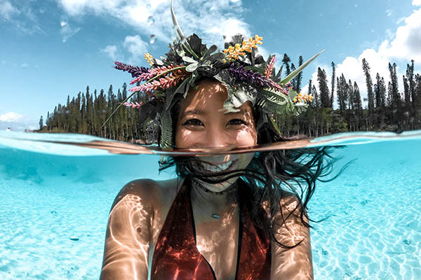 Close-up of a girl with flowers on her head Swimming in Oro Bay, Iles des Pines, New Caledonia