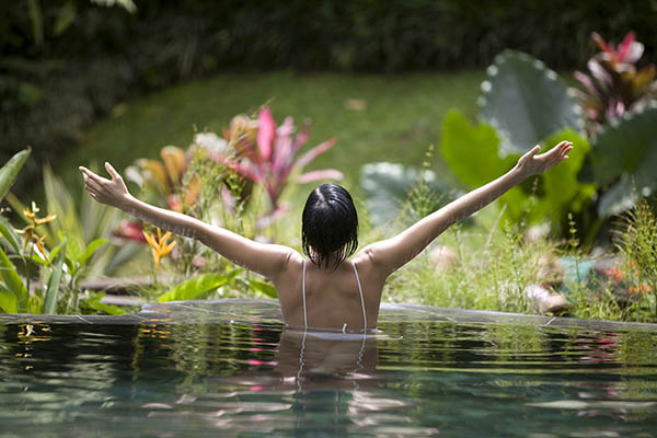 Woman in tropical lake practicing yoga pose