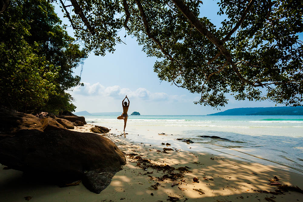 Woman practicing Vriksha asana on Koh Rong Island, Cambodia