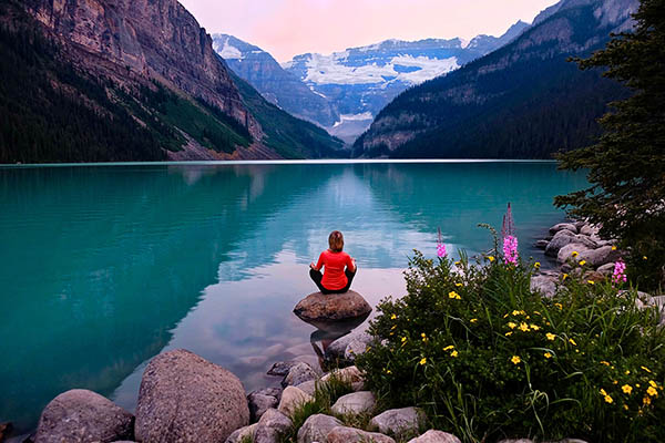 Woman meditating at Lake Louise in Banff National Park, Alberta, Canada