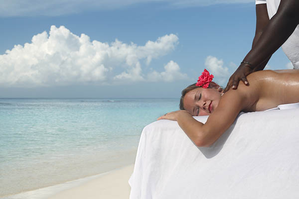 Woman getting a massage on a tropical beach