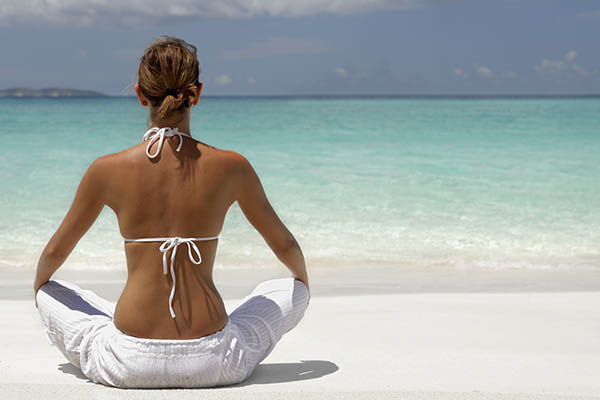 woman meditating on tropical beach in the caribbean