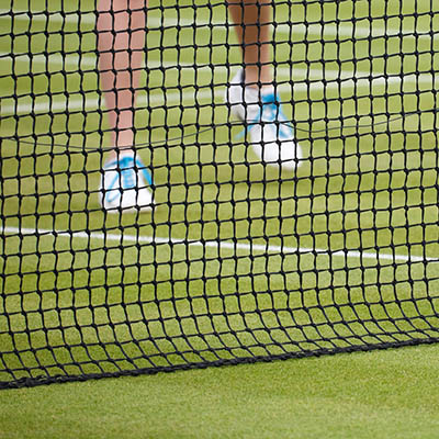 Female tennis player plays tennis on a grass court