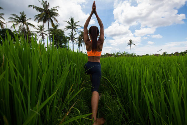 Young girl doing yoga in a rice field in Bali, Indonesia