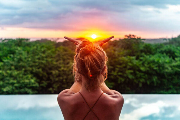 Woman in front of pool practicing yoga sun salutation in Malaysia