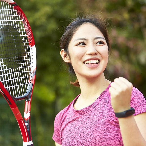 portrait of happy asian female tennis player