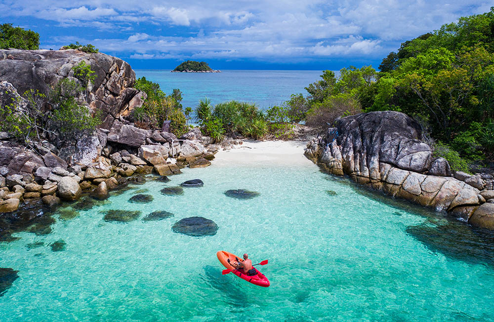 Aerial drone view of in kayak in crystal clear lagoon sea water during summer day near Koh Lipe island in Thailand