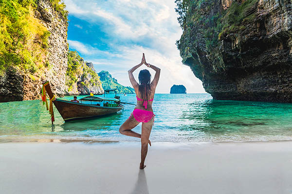 Woman practicing yoga on the beach at Poda Island, Krabi province, Thailand