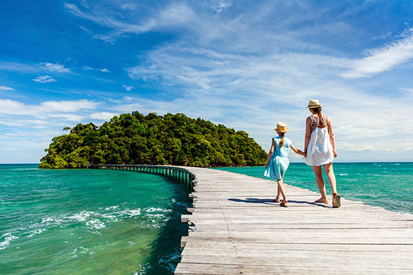 Mother & child walking across a bridge to a tiny island in Cambodia