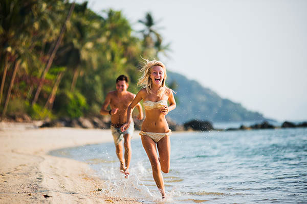 Honeymoon couple running by the sea