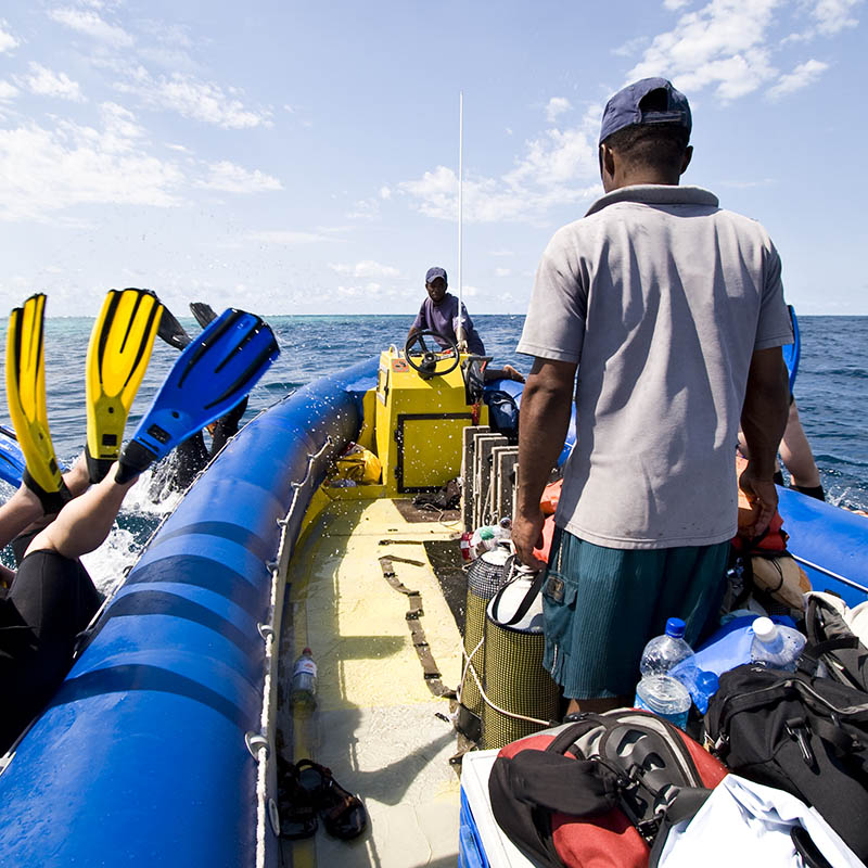 Scuba divers diving overboard from a dive boat