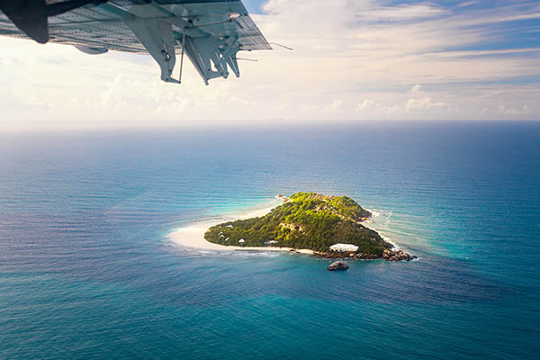 Plane flying over a small island in the Seychelles