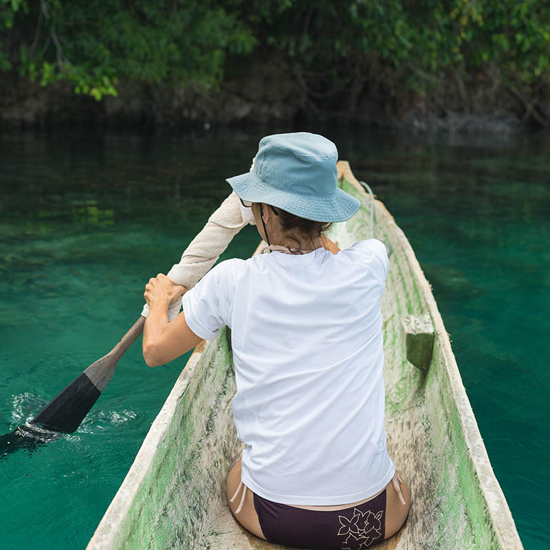 Female tourist paddling in traditional wooden canoe