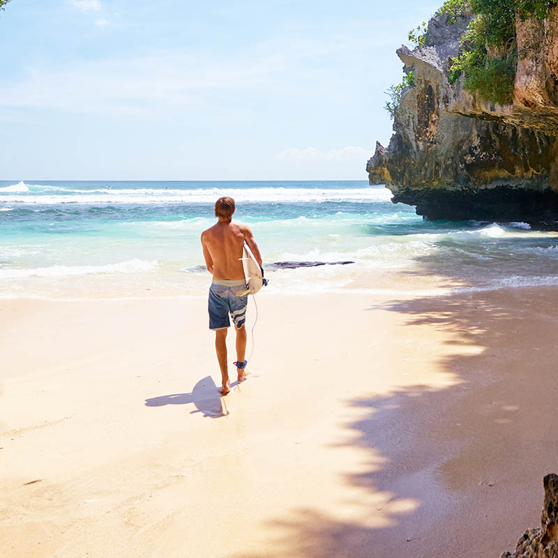 Surfer at Uluwatu spot, Bali island, Indonesia