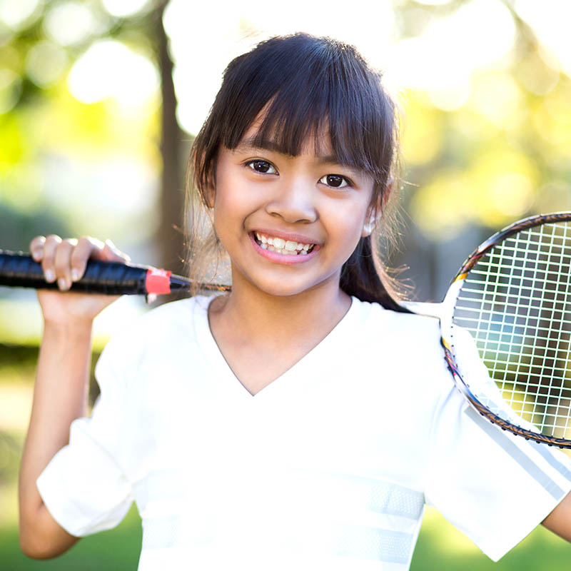 Close-up of a young Asian girl holding a badminton racket