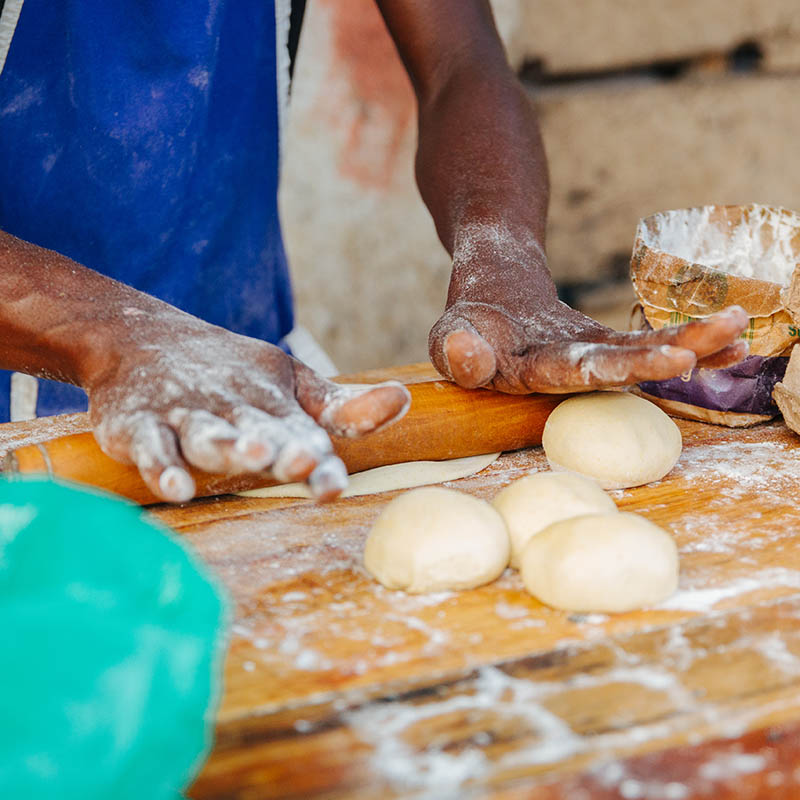 Man rolling out dough to make traditional flat bread