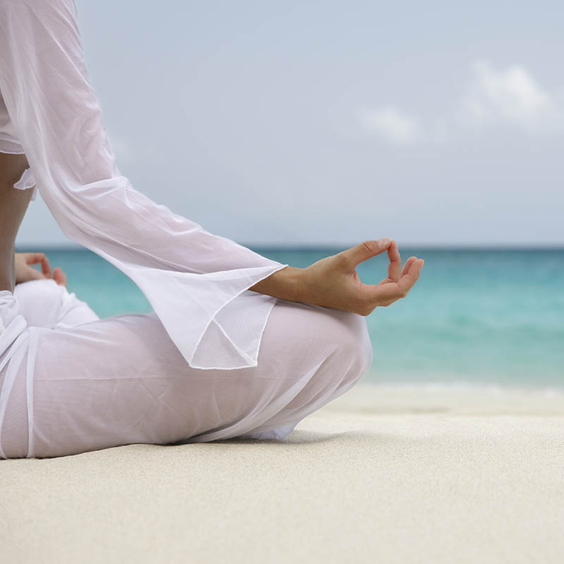 woman meditating on the beach 