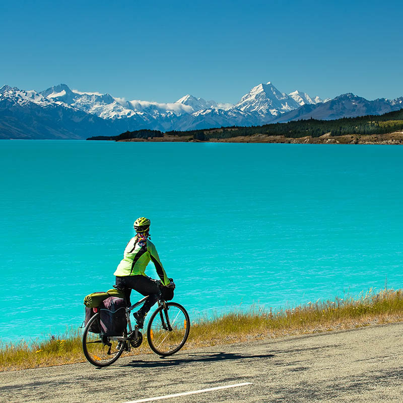 Cycling along a mountain road along Lake Pukaki view from Glentanner Park Centre near Mount Cook, New Zealand