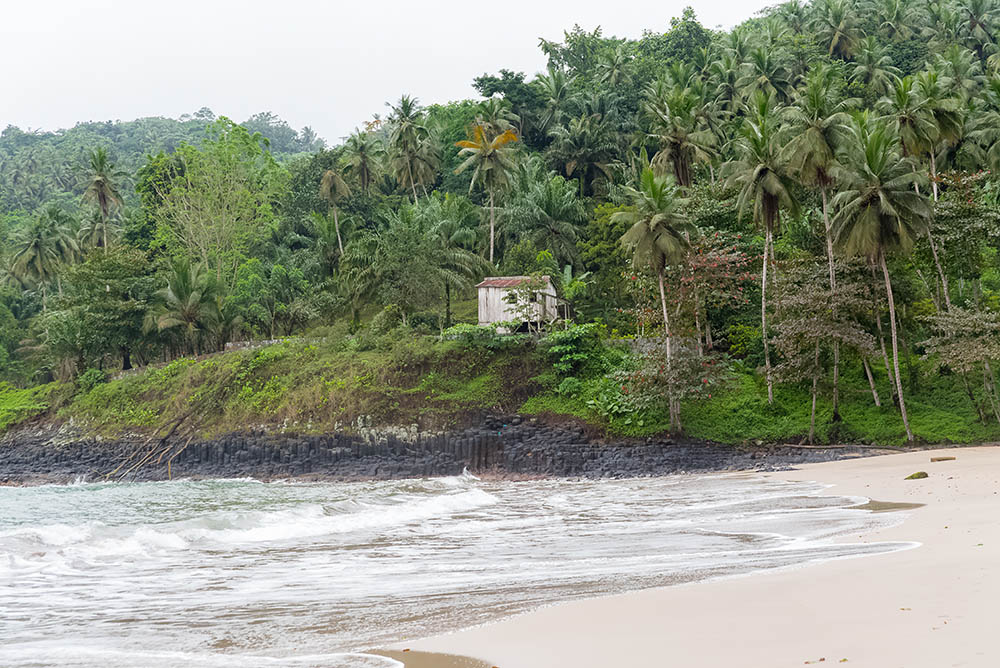 Sao Tome, typical house on the beach, palm trees on the cliff