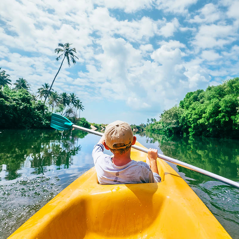 Boy kayaking in a tropical setting