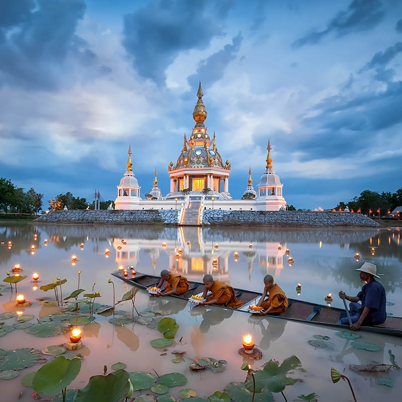 Novice monks laying lights on the water in Thailand