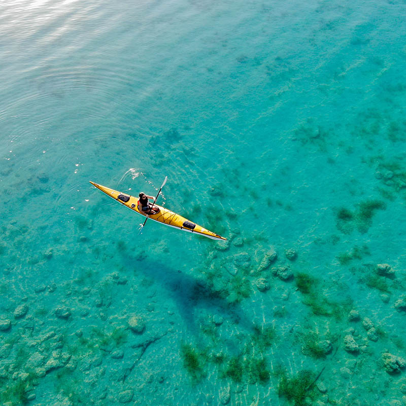 Woman kayaking on a clear ocean