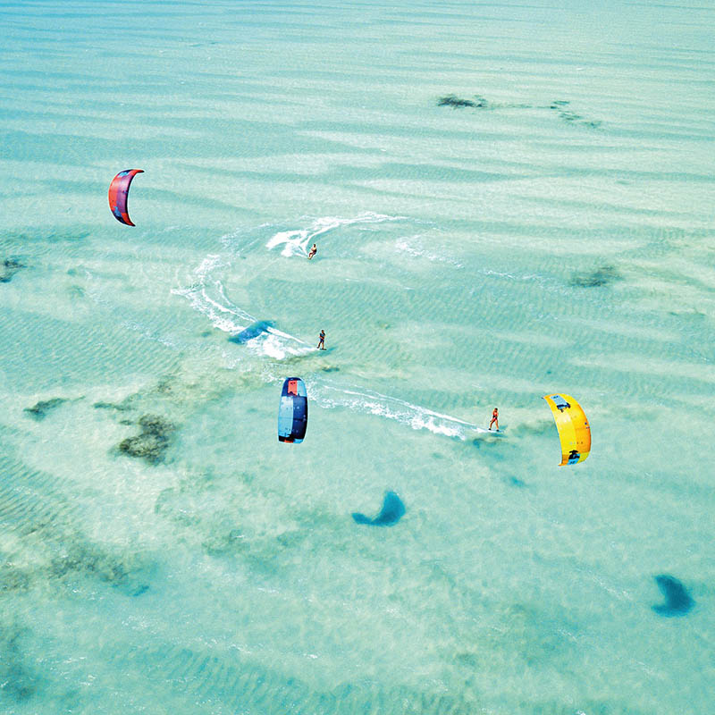 Kitesurfers on a turquoise ocean