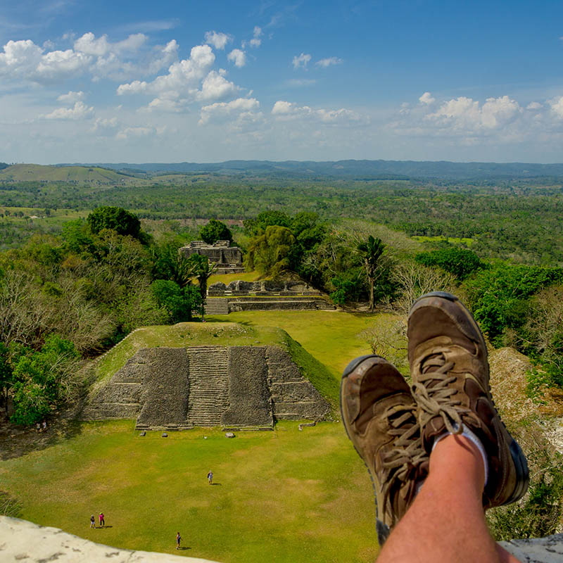 man's shoes overlooking xunantunich maya site ruins in belize