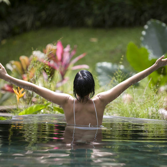 Woman in tropical lake practicing yoga pose