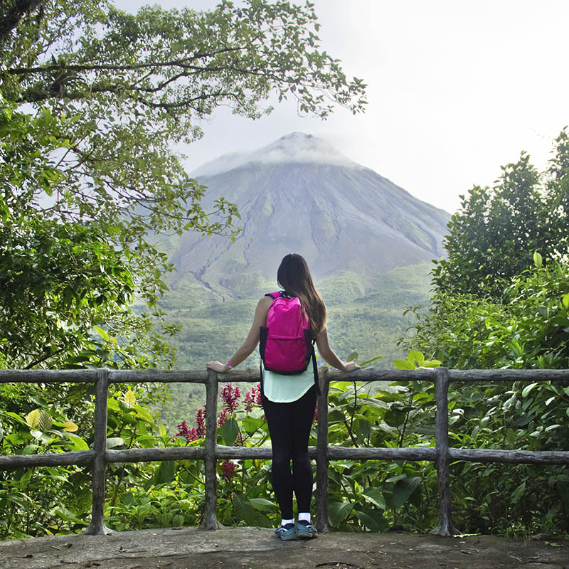 Female hiker looking out at the Arenal volcano in Costa Rica