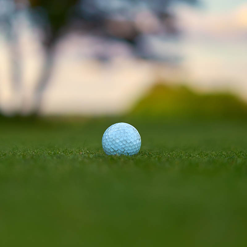 Defocused golf ball on the grass field