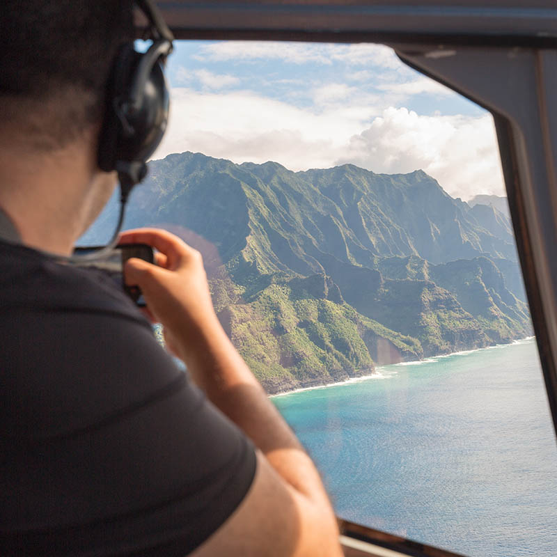 Napali coast from a helicopter with a tourist taking pictures - Kauai, Hawaii