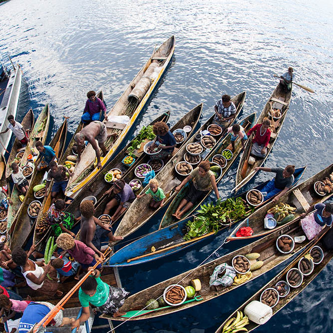 Villagers form a floating market, selling vegetables amid the Solomon Islands