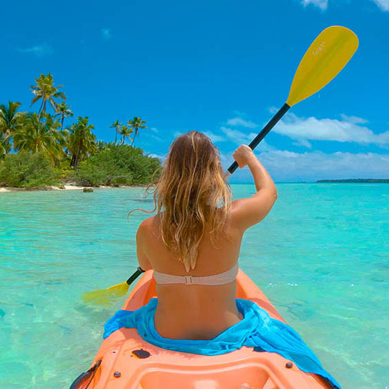 Young woman kayaking off a tropical beach