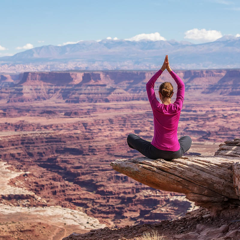 Woman meditating doing yoga in Canyonlands National park in Utah, USA