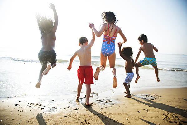 group of young children having fun on the beach