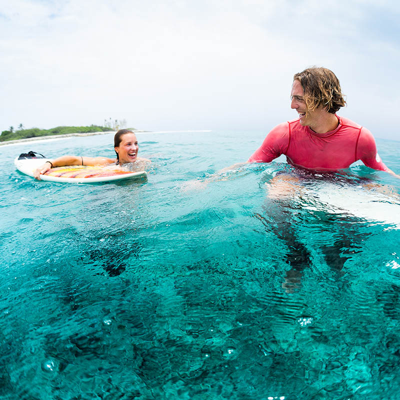 Two young and happy surfers have fun in the ocean