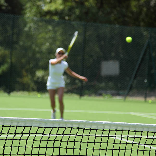 blurred woman playing tennis on a grass court in Ireland