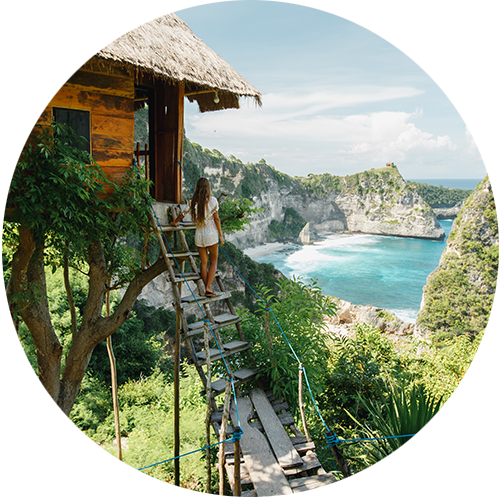 Young woman standing on a treehouse looking out to the ocean