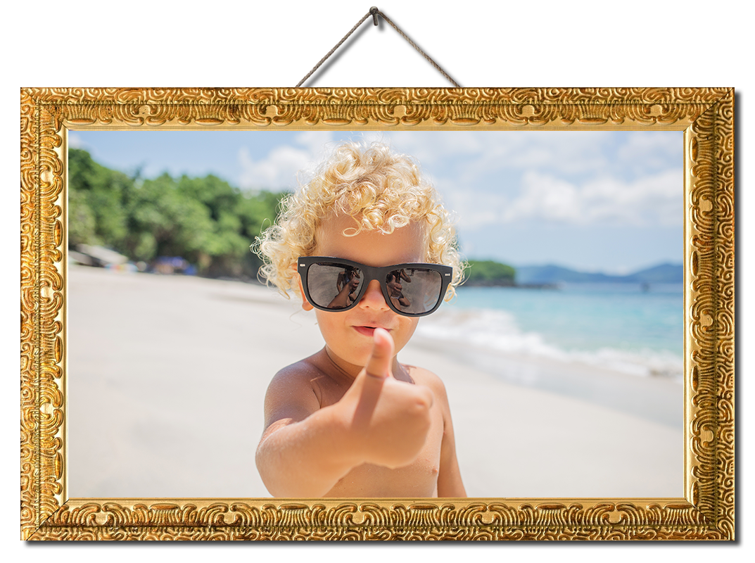 Young blond boy with sunglasses giving a thumbs up sign on the beach