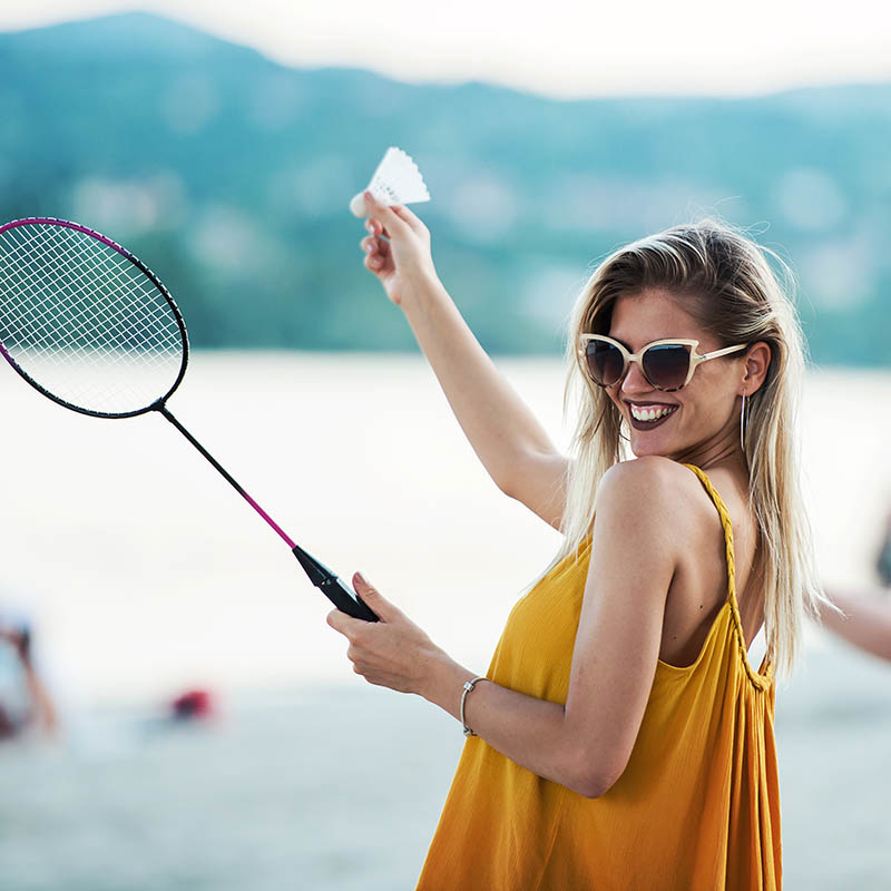 wo young girls playing badminton in the summer on a beach