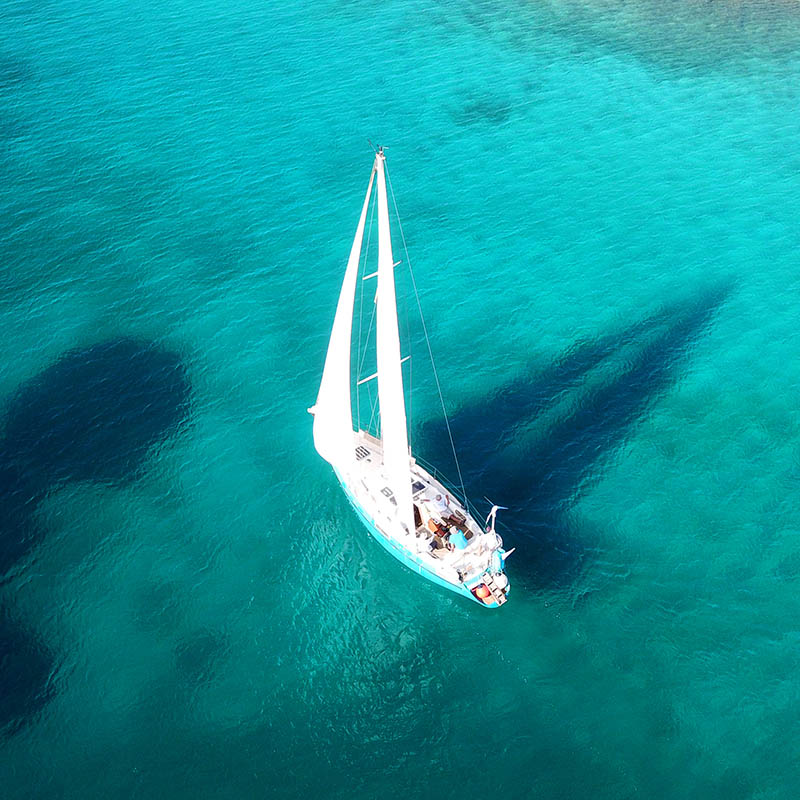 bird's eye view of a yacht cruising near a tropical island