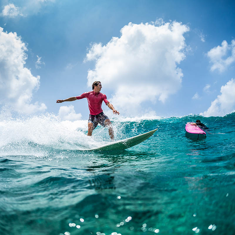 Surfer rides the wave at sunny day