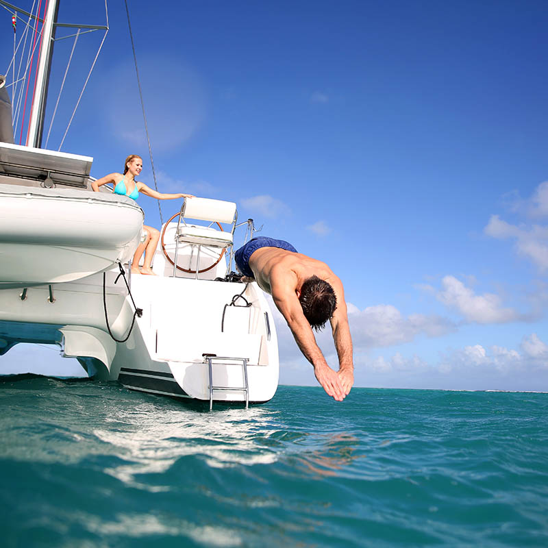 Man diving from catamaran deck into the sea